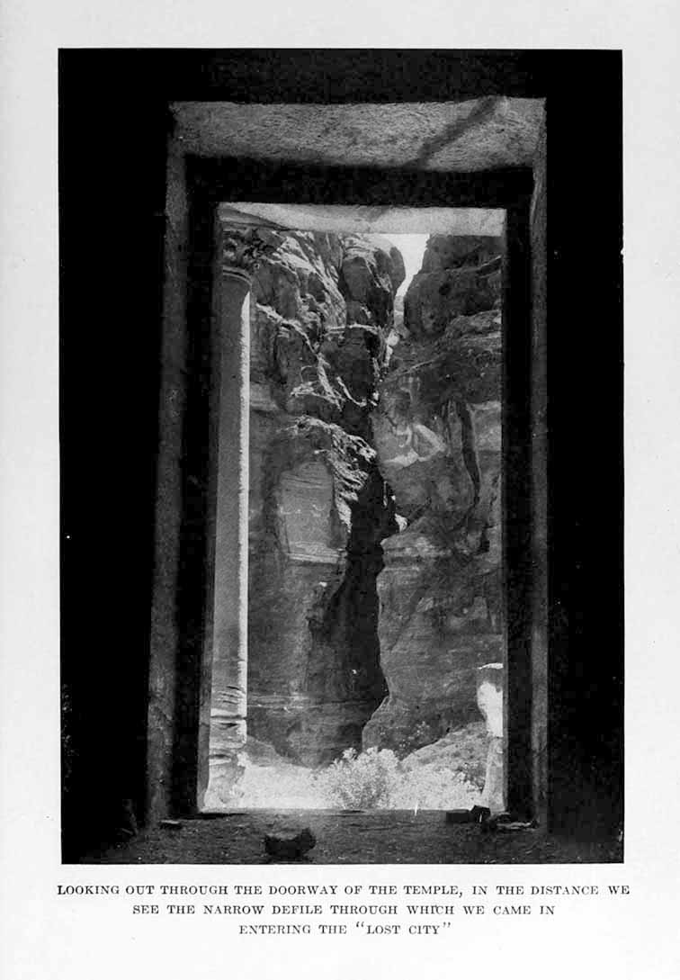 Photograph: LOOKING OUT THROUGH THE DOORWAY OF THE TEMPLE,
    IN THE DISTANCE WE SEE THE NARROW DEFILE THROUGH WHICH WE CAME IN ENTERING THE “LOST CITY”